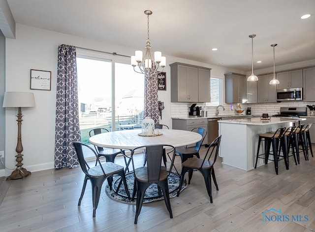 dining space featuring an inviting chandelier and light hardwood / wood-style flooring