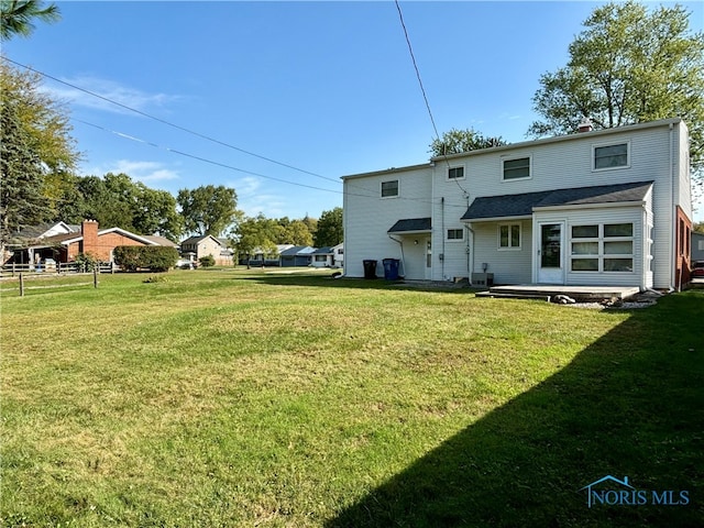 rear view of house featuring a yard