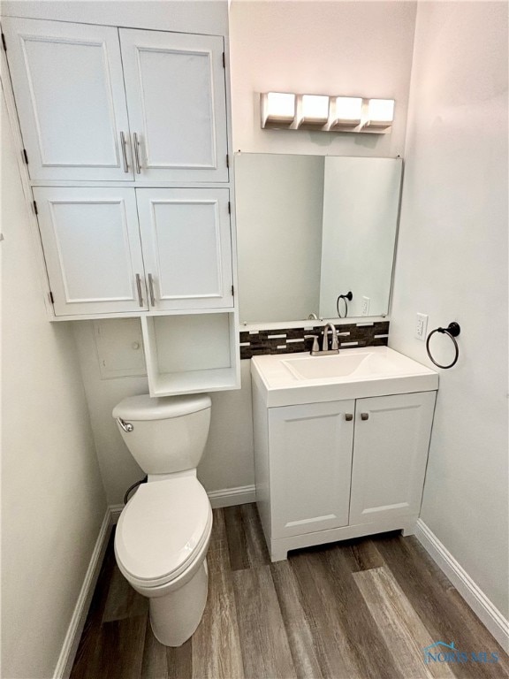 bathroom with hardwood / wood-style floors, vanity, and toilet