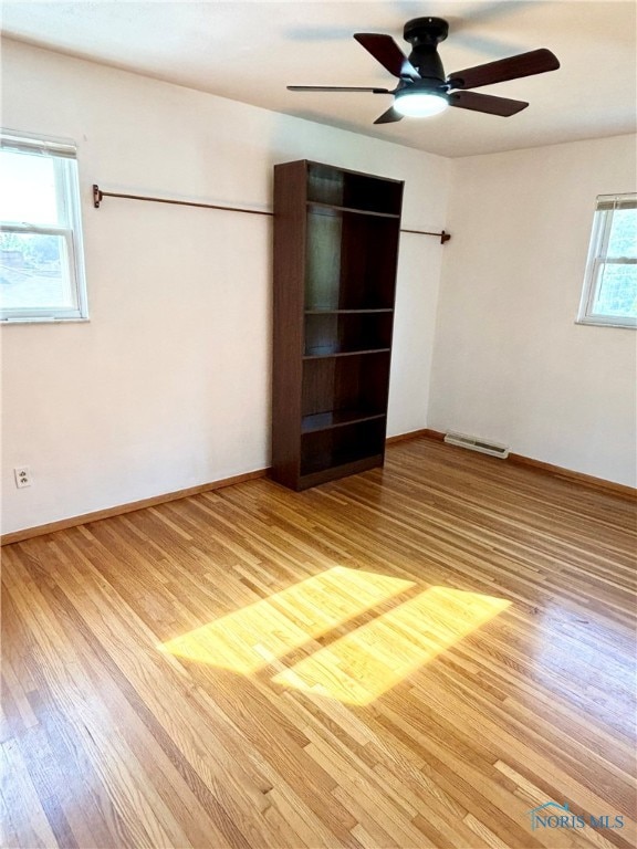 empty room with wood-type flooring and ceiling fan