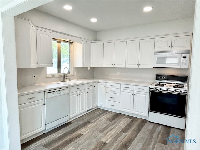 kitchen with white appliances, white cabinetry, dark wood-type flooring, and sink