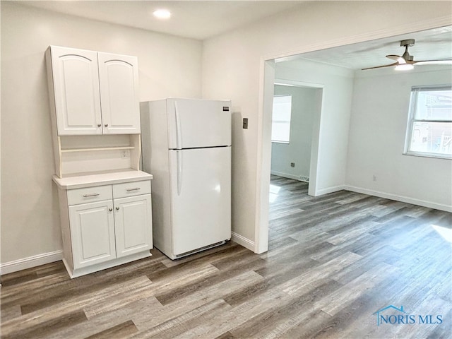 kitchen with light hardwood / wood-style flooring, white cabinets, ceiling fan, and white fridge