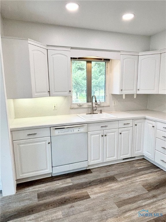 kitchen featuring white dishwasher, dark hardwood / wood-style floors, white cabinetry, and sink