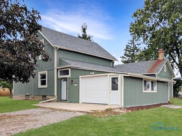 view of front of property with a front yard and a garage