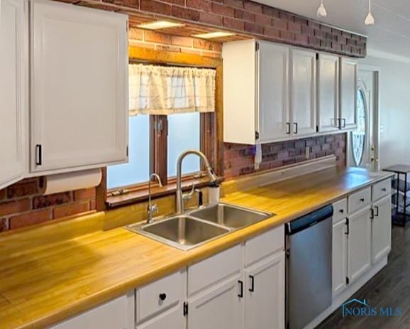 kitchen featuring tasteful backsplash, stainless steel dishwasher, sink, white cabinets, and dark hardwood / wood-style floors