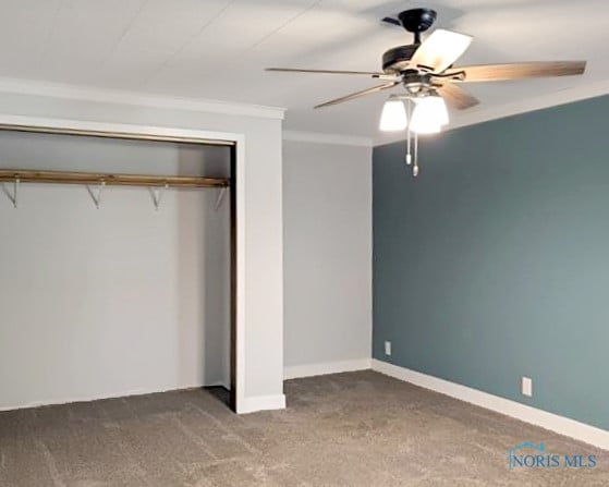 unfurnished bedroom featuring ceiling fan, a closet, carpet, and ornamental molding