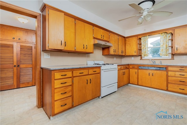 kitchen featuring ceiling fan, sink, and white stove