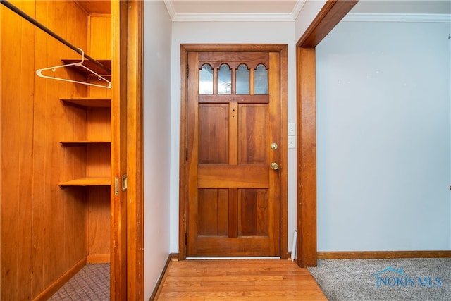 entryway with crown molding and light hardwood / wood-style flooring