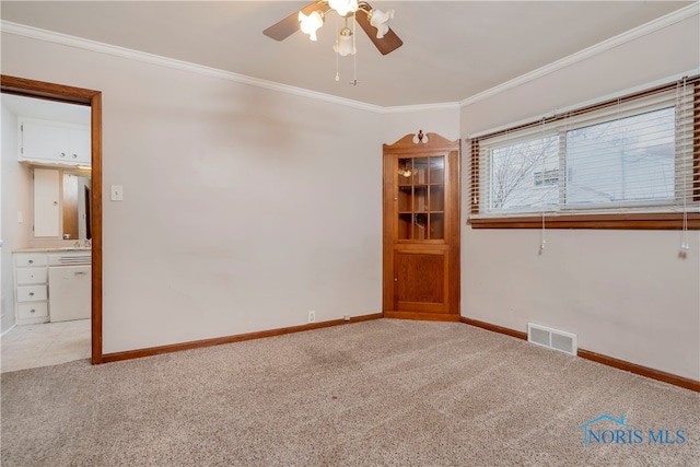 spare room featuring light carpet, ceiling fan, and crown molding