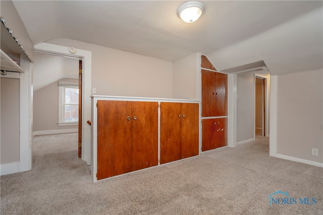 bonus room with light carpet and lofted ceiling