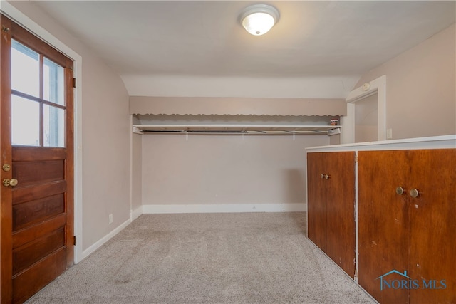 walk in closet featuring light colored carpet and lofted ceiling