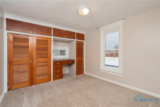 unfurnished bedroom with light carpet and a closet