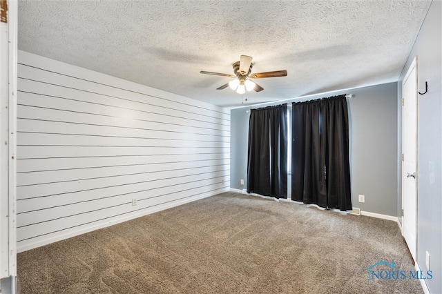 spare room featuring ceiling fan, a textured ceiling, and carpet