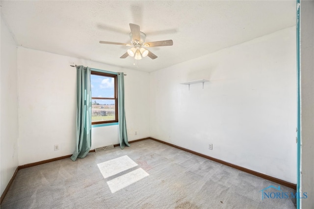 carpeted spare room with ceiling fan and a textured ceiling