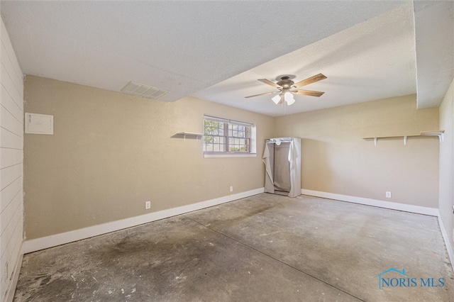 spare room with ceiling fan, a textured ceiling, and concrete floors