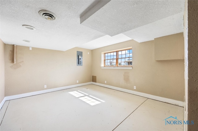 basement featuring a textured ceiling and electric panel