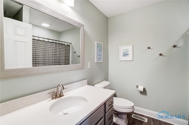 bathroom featuring curtained shower, wood-type flooring, vanity, and toilet