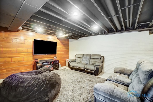 living room with carpet floors and wooden walls