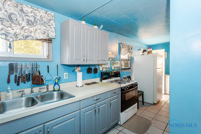 kitchen featuring light tile patterned flooring, white appliances, and sink