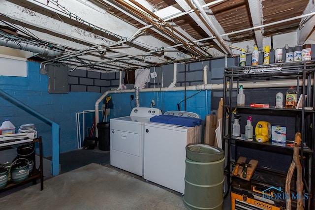 basement with electric panel and washer and clothes dryer