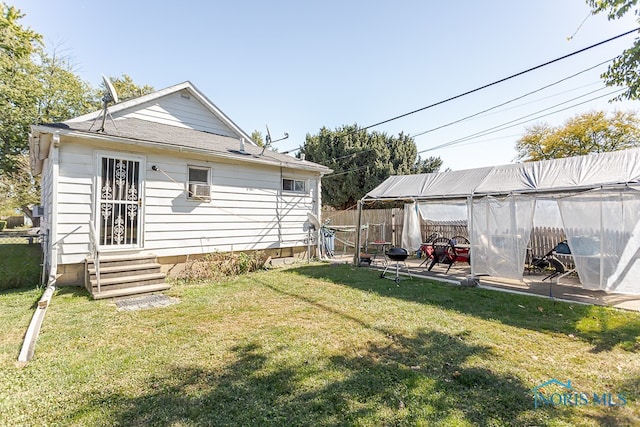 rear view of house with a patio and a yard