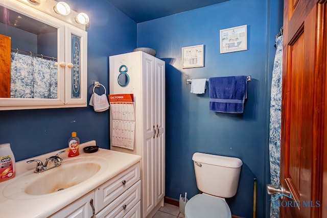 bathroom with tile patterned flooring, vanity, and toilet