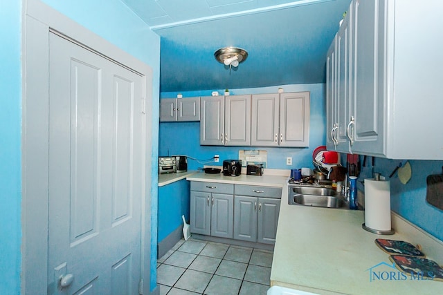 kitchen featuring gray cabinets, sink, and light tile patterned floors