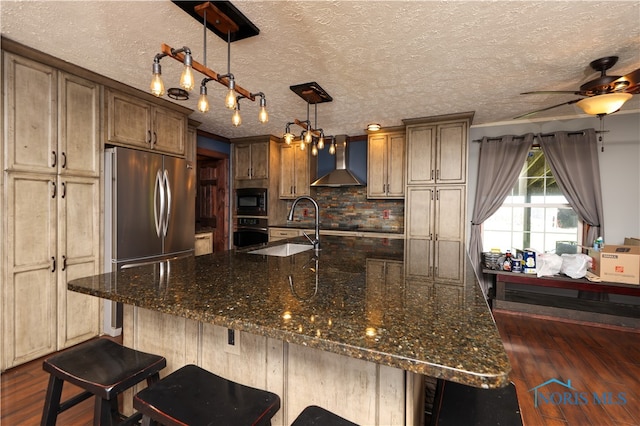 kitchen featuring wall chimney range hood, pendant lighting, dark hardwood / wood-style flooring, built in microwave, and black oven