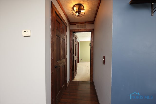 hall featuring a textured ceiling and dark hardwood / wood-style flooring