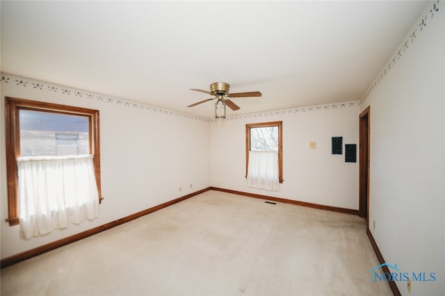 carpeted spare room with ceiling fan