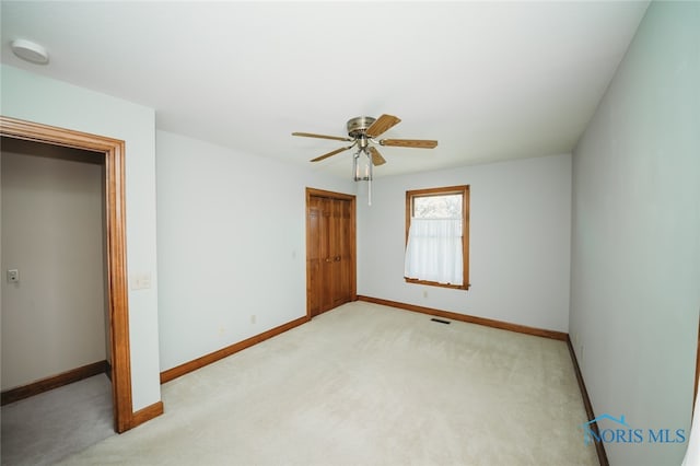 unfurnished bedroom with a closet, ceiling fan, and light colored carpet