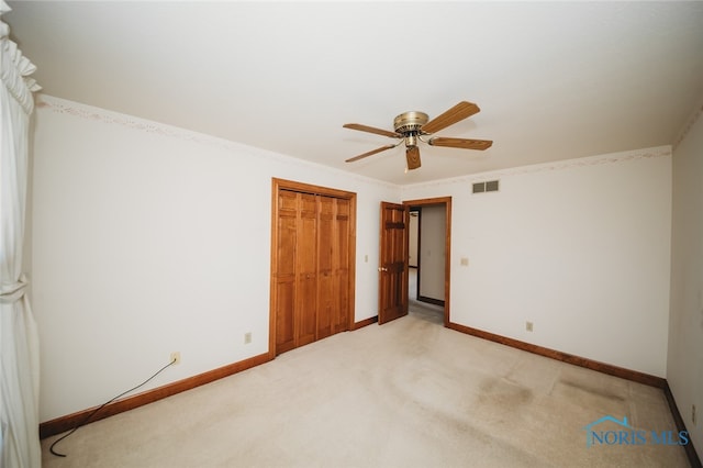 unfurnished bedroom featuring ceiling fan, a closet, and carpet flooring