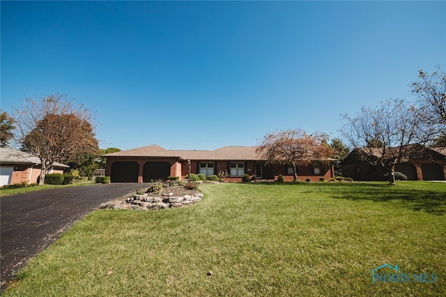 ranch-style home featuring a front lawn and a garage