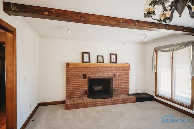 unfurnished living room with beam ceiling, a brick fireplace, and carpet