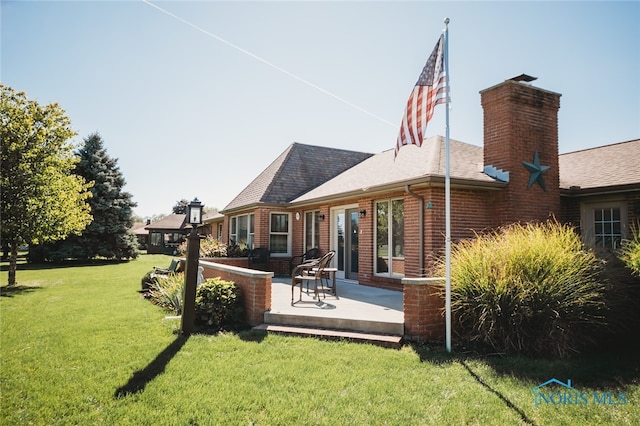 rear view of house featuring a patio and a yard