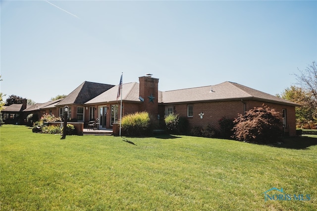 back of property featuring a lawn and a wooden deck