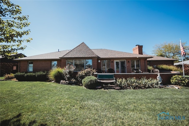 rear view of property with a lawn