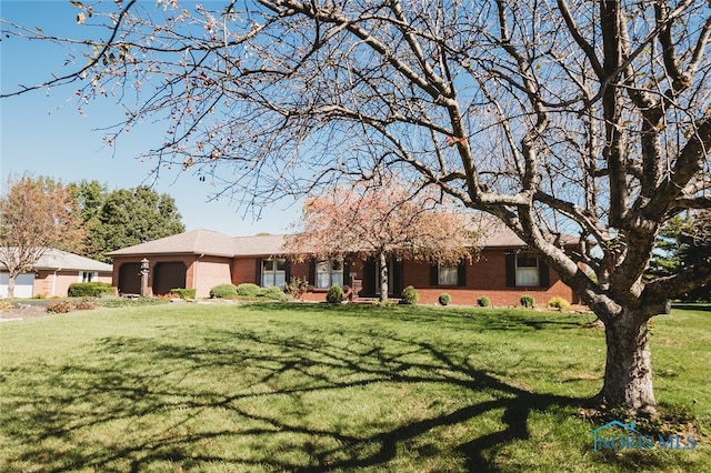 ranch-style house with a garage and a front lawn