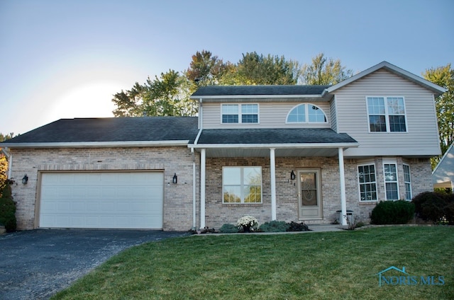 view of front property featuring a garage and a front lawn