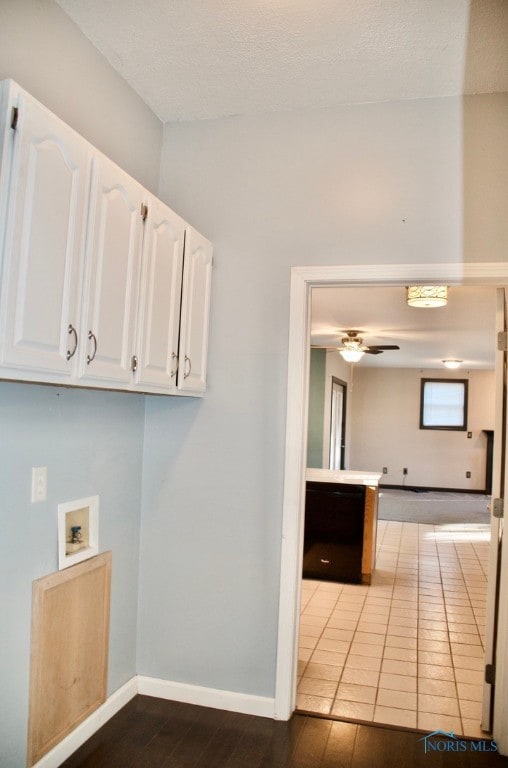 clothes washing area featuring cabinets, a textured ceiling, light tile patterned floors, ceiling fan, and hookup for a washing machine