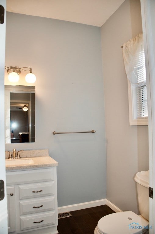 bathroom featuring hardwood / wood-style floors, vanity, and toilet