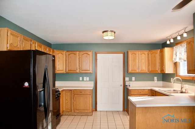 kitchen featuring light tile patterned flooring, sink, kitchen peninsula, black appliances, and light brown cabinets