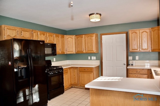 kitchen with black appliances, kitchen peninsula, and light tile patterned floors