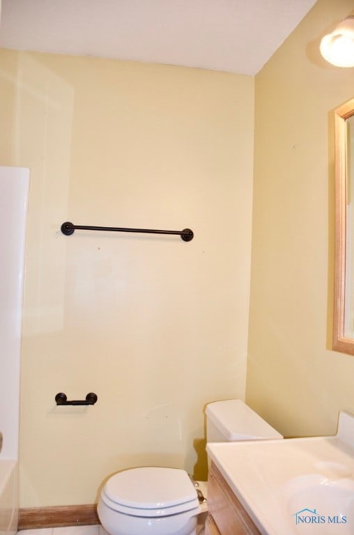 bathroom with a bathtub, vanity, and toilet