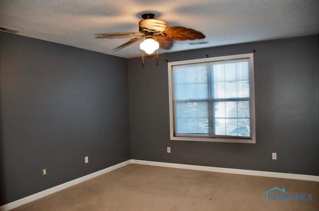 carpeted empty room featuring ceiling fan