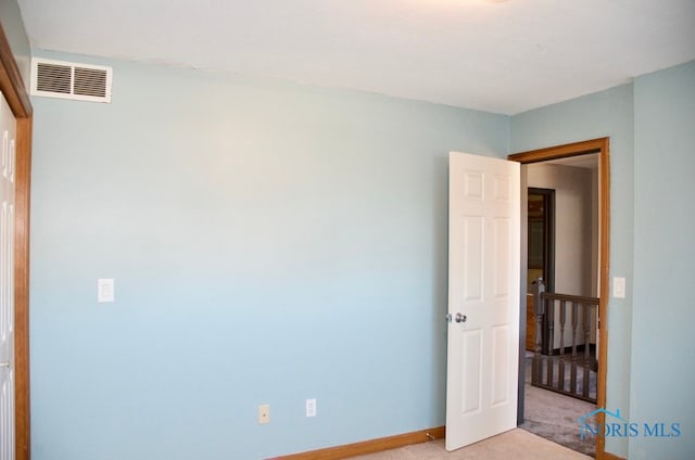 unfurnished bedroom featuring light carpet