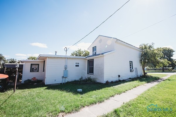 back of property featuring a lawn