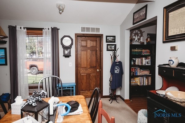 dining room with lofted ceiling and hardwood / wood-style floors