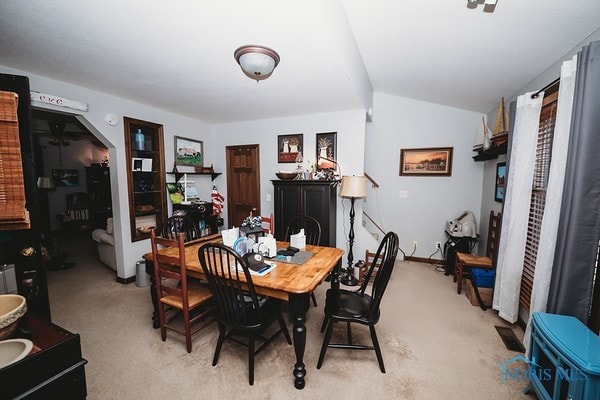 dining space with light carpet and lofted ceiling