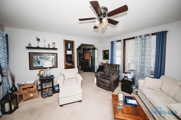 carpeted living room with ceiling fan